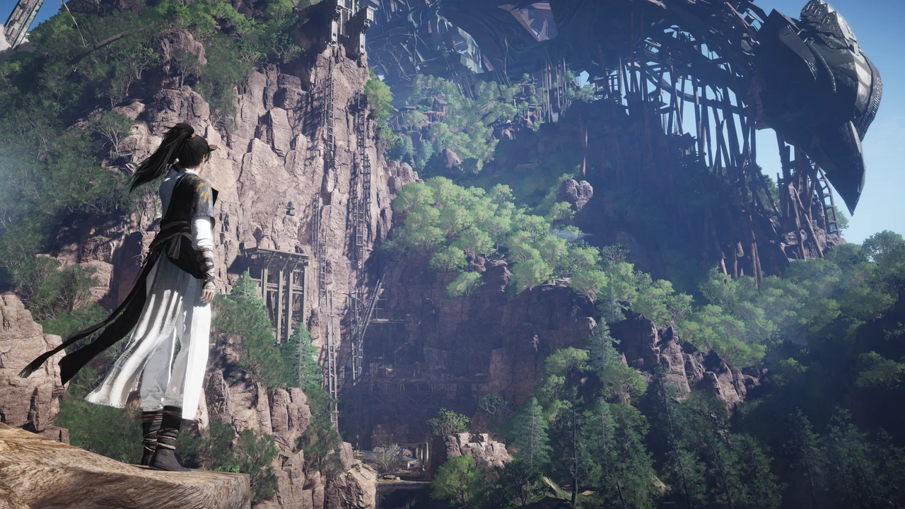 A wanderer in white robes stands on a cliff edge facing a vast ruined wooden structure on the mountain above.